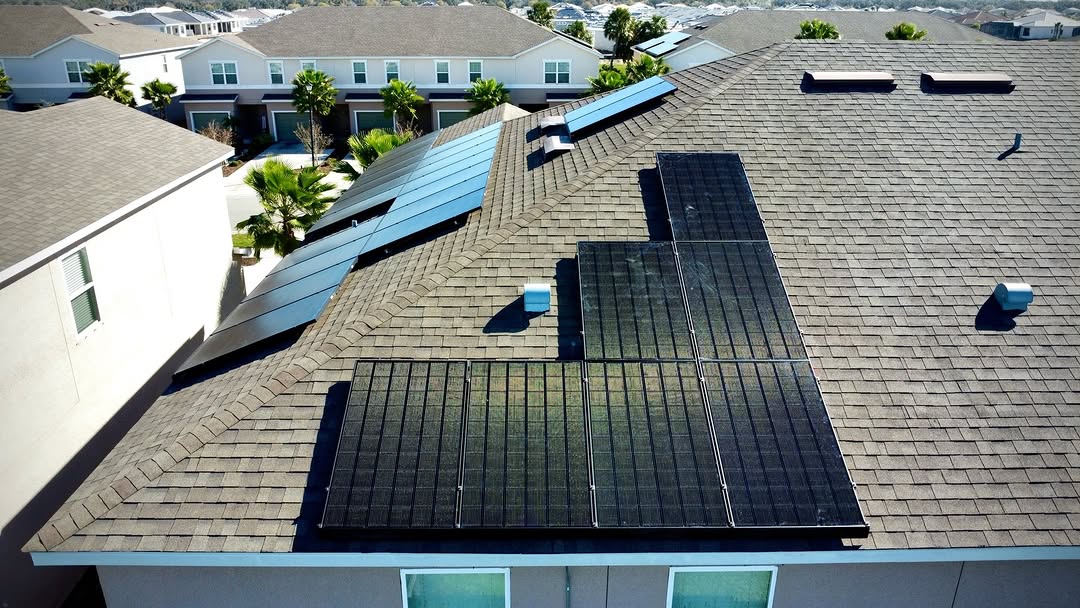 Solar panels arranged on several roof planes of a shingle-roof home